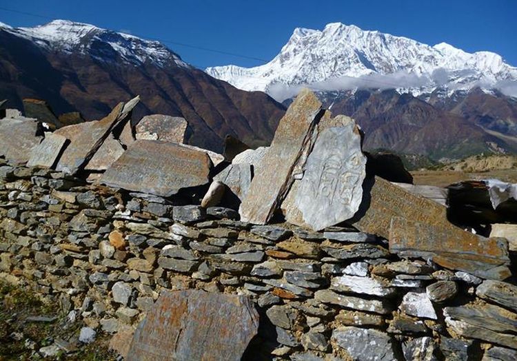 Mani Wall ( Buddhist shrine ) with Prayer Flags and Prayer Wheels